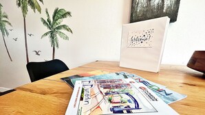 A wooden table with a welcome sign and several travel magazines. - BlueJay's Nest Unit B: Game Room, Walk to Water & Stadium (Clearwater)