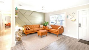 A modern living room with a sectional sofa, a small table, and a plant. - BlueJay's Nest Unit B: Game Room, Walk to Water & Stadium (Clearwater)