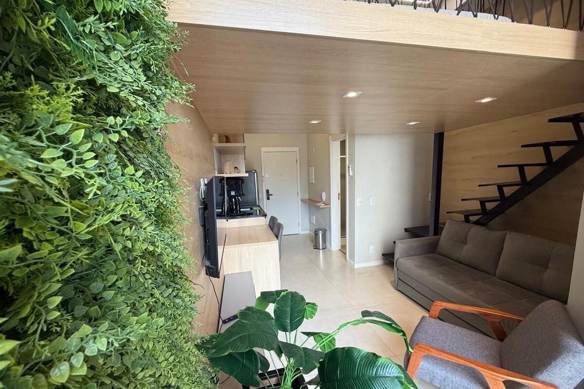 Un salon moderne avec un canapé, des fauteuils, une table basse et un escalier.