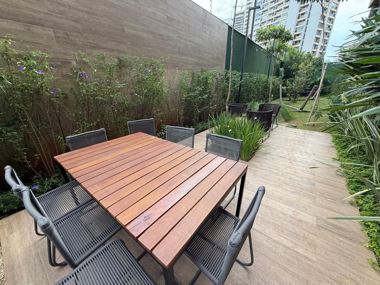 A wooden table with metal chairs in an outdoor setting.