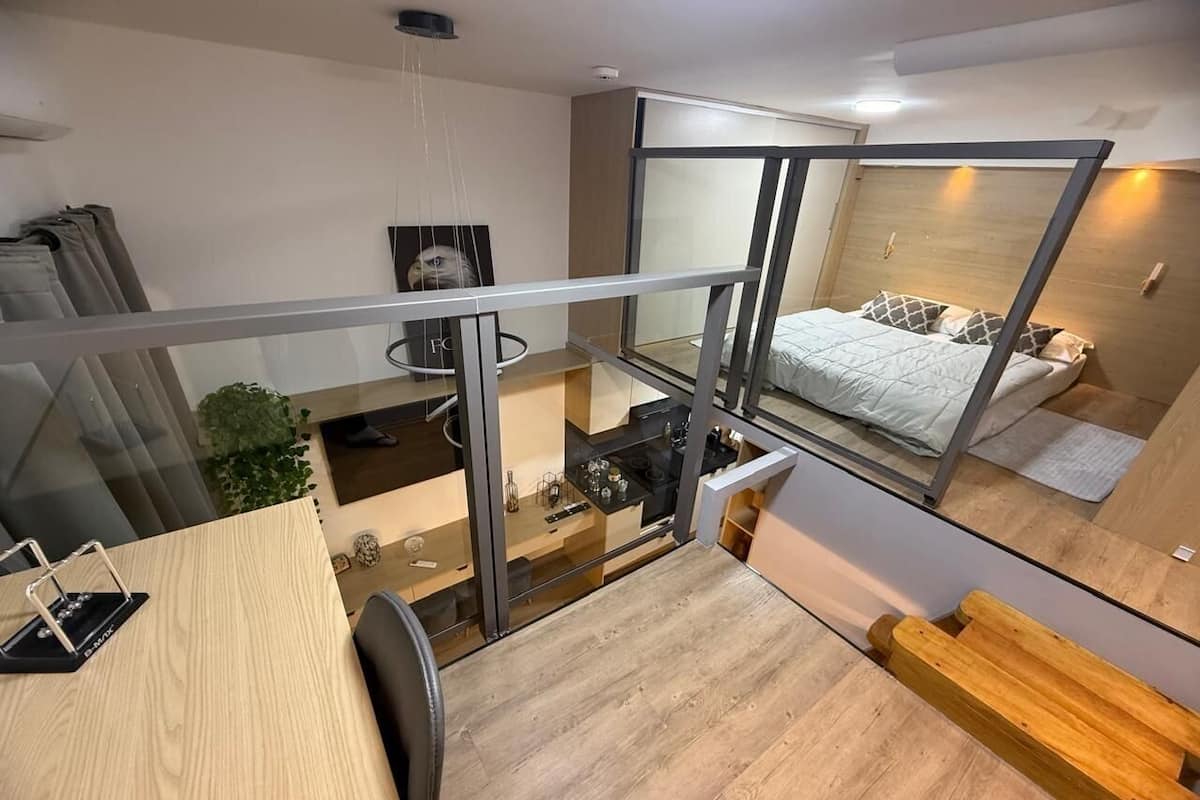 Un appartement moderne doté d’un balcon, d’une cuisine et d’une chambre à coucher avec un lit et une fenêtre.