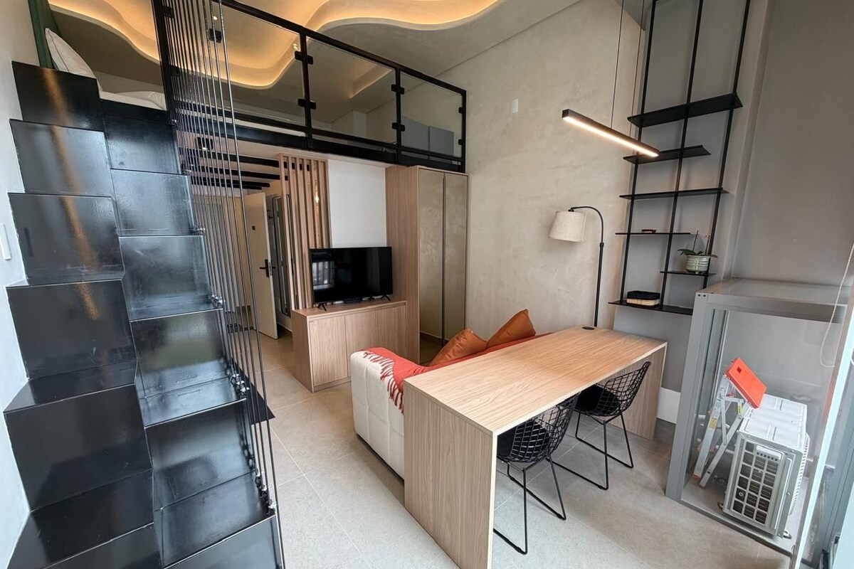 Un intérieur moderne comprenant un escalier, un coin repas et une cuisine.