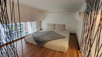 A bedroom with a bed, a window, and a ceiling light.