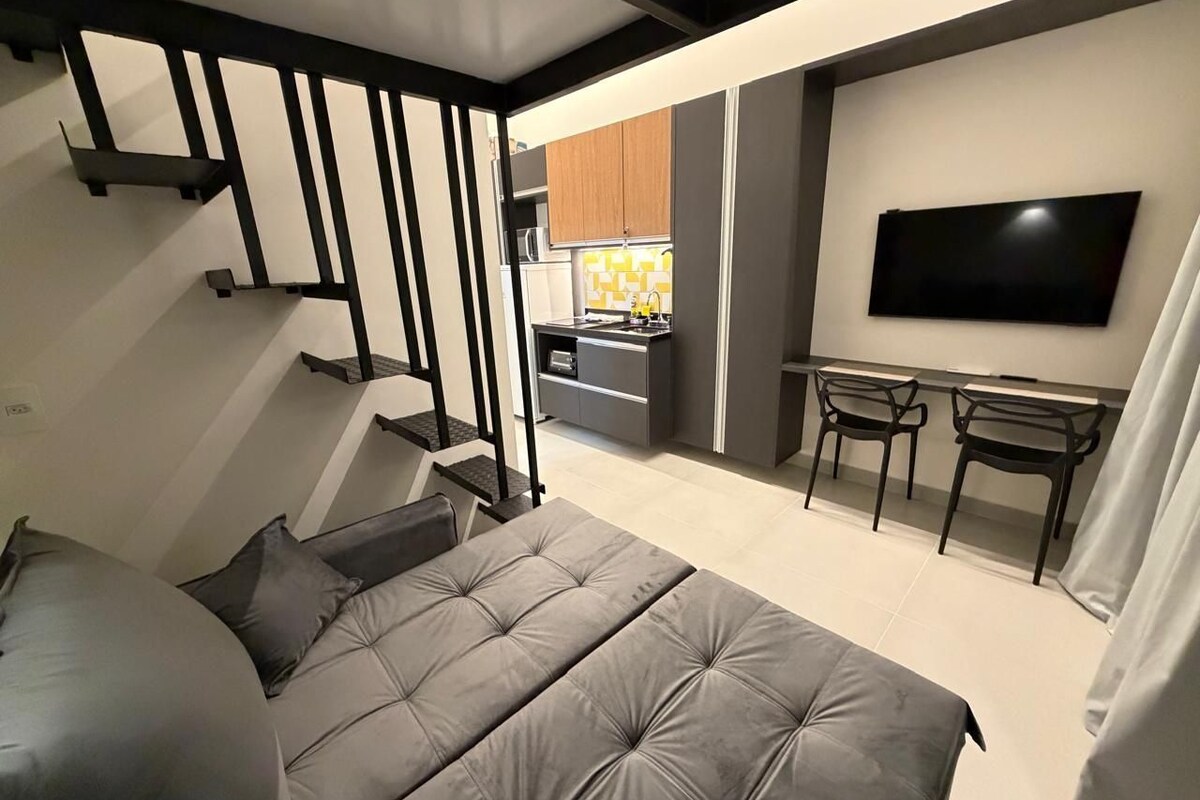 Une chambre à coucher moderne avec un lit, un bureau et un téléviseur.