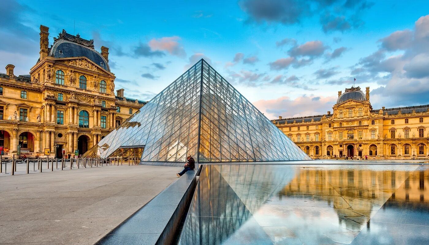 The Louvre Pyramid with a clear view of the surrounding classical architecture.