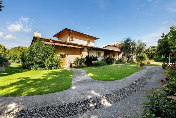 A house with a paved driveway, a gravel path, and a well-maintained lawn.