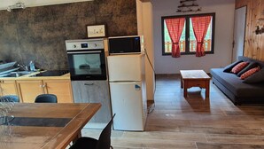 A compact living space with a kitchenette, a dining area, and a seating area with a sofa.