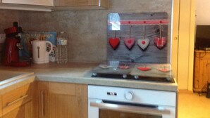 A kitchen with a stove, cabinets, and a microwave.