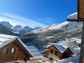 A mountain lodge with wooden cabins, snow-covered roofs, and a view of snow-capped mountains. - Chalet for 8 facing south, terrace, private parking (Valloire)