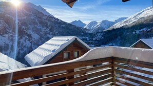 A wooden cabin with a balcony overlooking a snowy mountain landscape. - Chalet for 8 facing south, terrace, private parking (Valloire)