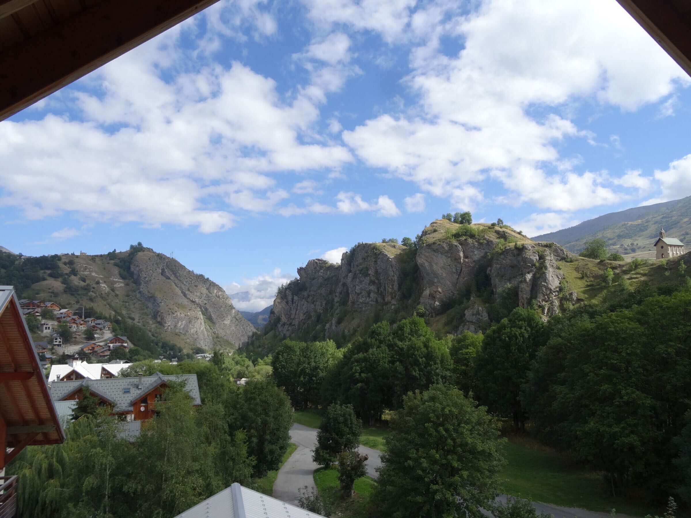 A mountainous landscape with a village, a church, and a winding road.