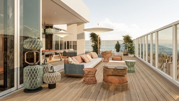 Un espacio exterior moderno con sofá, mesa de comedor y diversos objetos decorativos.