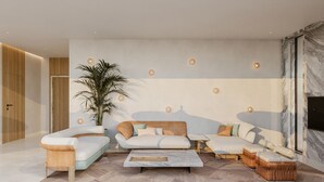 Una sala de estar moderna con un conjunto de sofá, una mesa de centro y una planta grande en maceta.