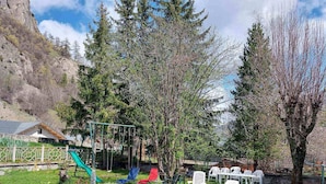 A backyard with a swing set, a slide, and outdoor seating. - Apartment for 5 people, pets allowed in Valloire (Valloire)