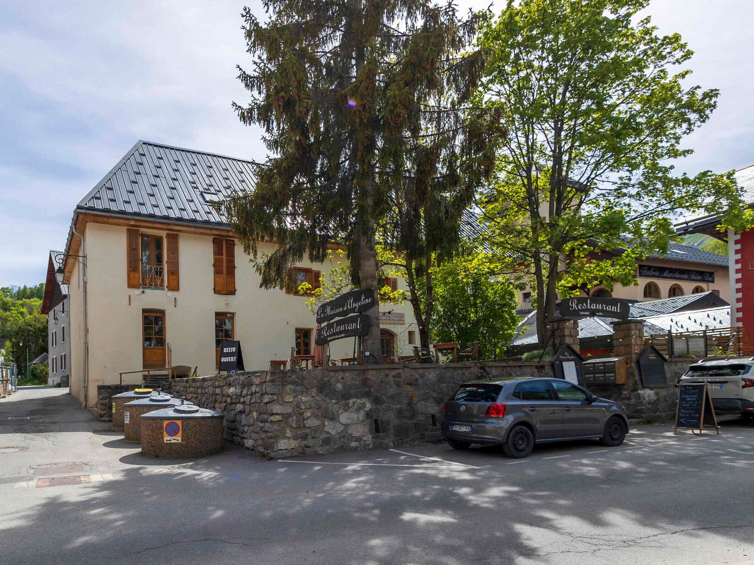 Ein Gebäude mit steinernen Mauern, einem Parkplatz und einem Schild für ein Restaurant.