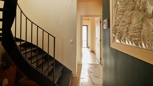 A spiral staircase with a wooden finish, a hallway leading to a door, and a wall-mounted map. - Spacious chalet for 11, 4 rooms, parking, sunny terrace (Valloire)