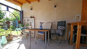 Un intérieur rustique avec une table en bois, des chaises en osier et une grande roue.