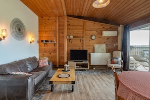 A cozy living room with a sofa, coffee table, TV, and a chair.