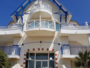 A multi-story hotel with a white facade, blue balconies, and a sign reading "ATLANTICA".