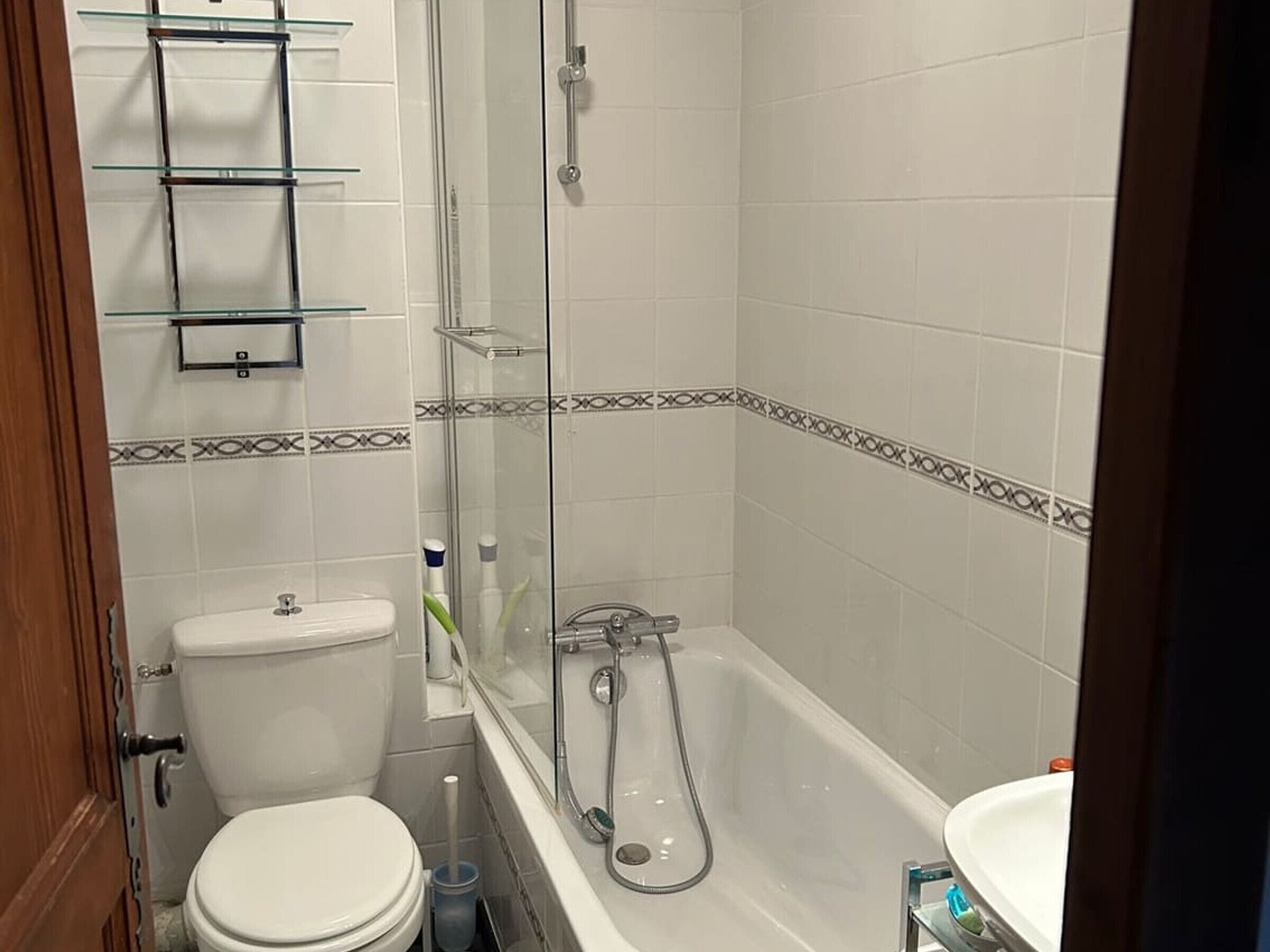 A bathroom with a toilet, a glass shower enclosure, and a bathtub.