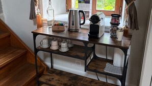 A kitchen with a wooden table, a kettle, a bottle, and a window with curtains. - Guest Room – Château de la Rive – Sleeps 10 (Cruet)