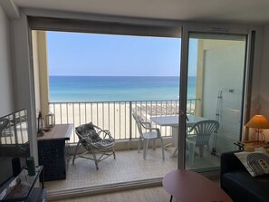 A balcony with a view of the beach, white chairs, a table, and a sofa. - T2 Apartment with AC and Sea Views in Canet-en-Roussillon (Canet-en-Roussillon)