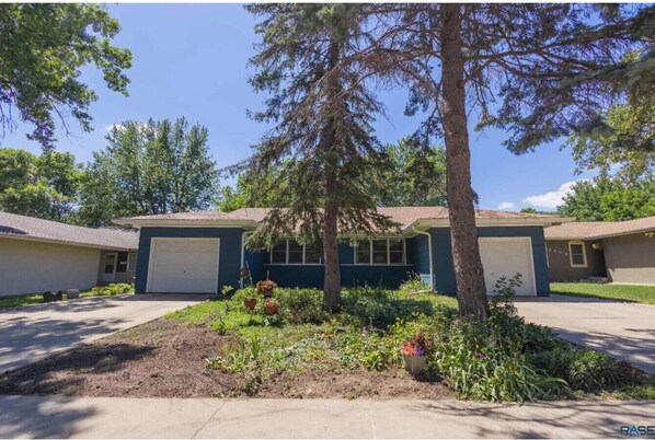 A two-story house with a front yard, a driveway, and a garage.