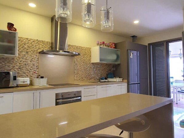 A modern kitchen with a central island, stainless steel appliances, and pendant lighting. - Luxury apartment in La Caleta near restaurants (La Caleta)