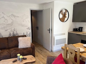 Una sala de estar acogedora con un sofá, una mesa de centro y un comedor con mesa y sillas de madera.