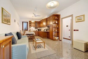 A living room with a sofa, coffee table, and a dining area with chairs and a table.
