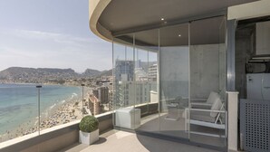 Un balcon moderne offrant une vue dégagée sur une plage et le paysage urbain.