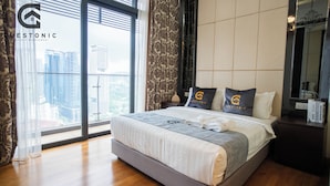 Una habitación de hotel moderna con una cama grande, vistas a la ciudad y una ventana con cortinas translúcidas.