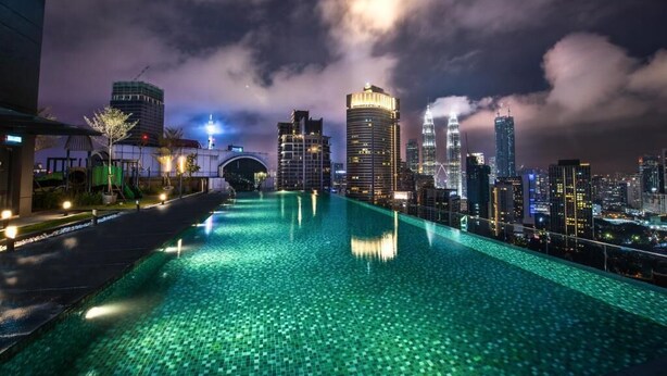 Una piscina infinita en la azotea, con un horizonte urbano de fondo.