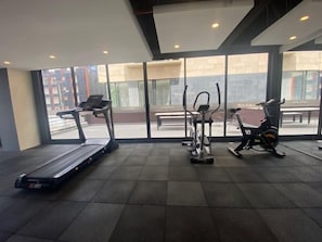 A gym with a treadmill, elliptical, and stationary bike. - Edificio Area 93  (Bogotá)
