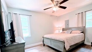 A bedroom with a bed, a ceiling fan, a desk with a computer, and a window with curtains. - Cozy home near Latta Nature Preserve (Huntersville)