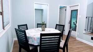 A dining area with a round table, four chairs, and a floral tablecloth. - Cozy home near Latta Nature Preserve (Huntersville)
