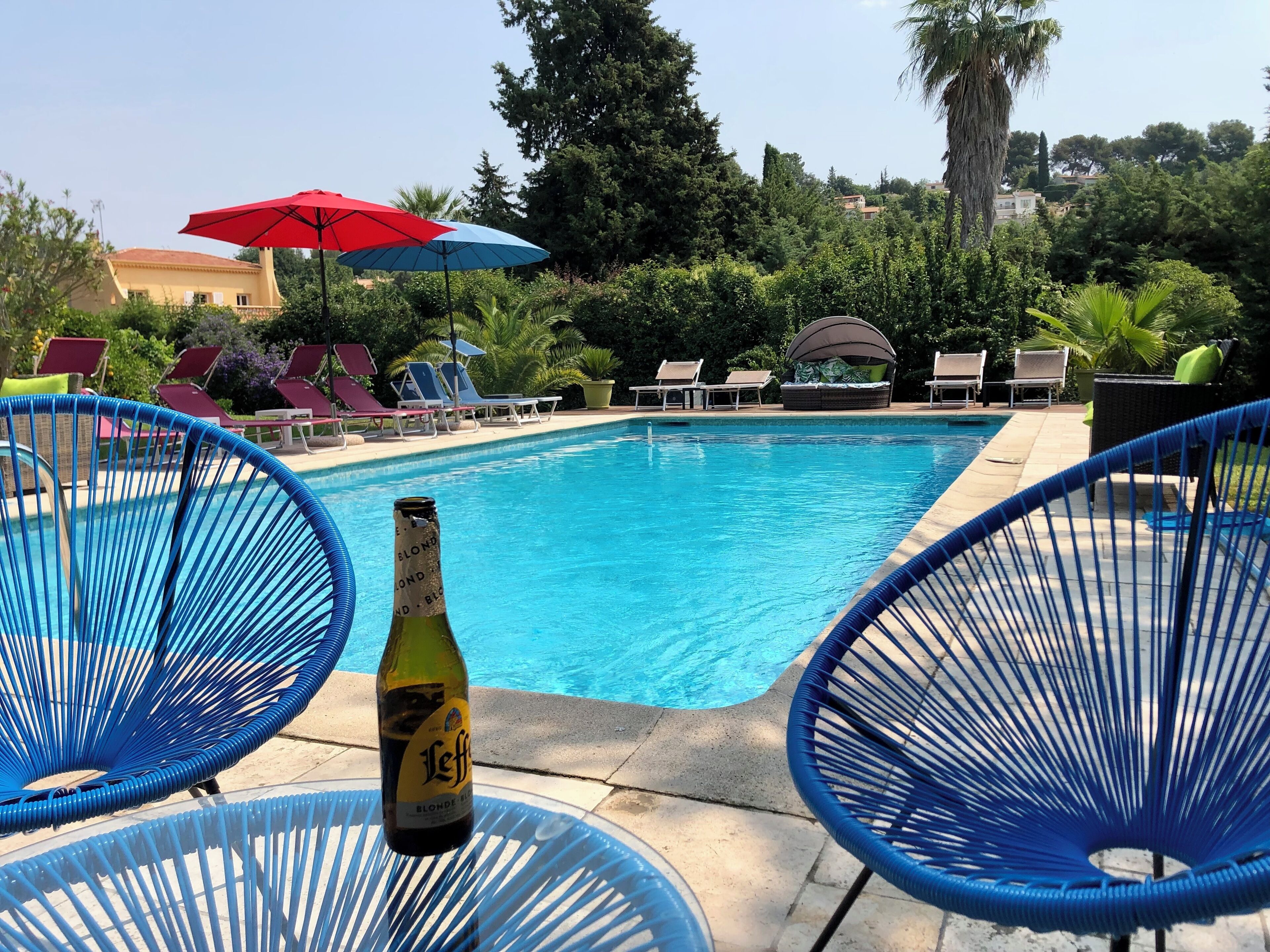Une piscine avec des chaises longues et des parasols.