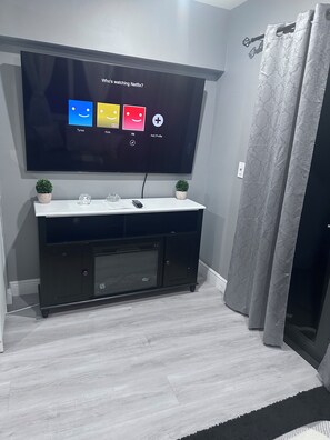 A flat-screen TV mounted on a wall with a screen displaying a Netflix interface.