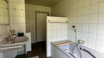Un baño con lavamanos, espejo y bañera.