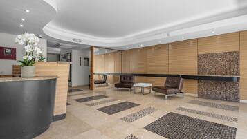 A modern reception area with a curved reception desk, seating area, and decorative tiles.