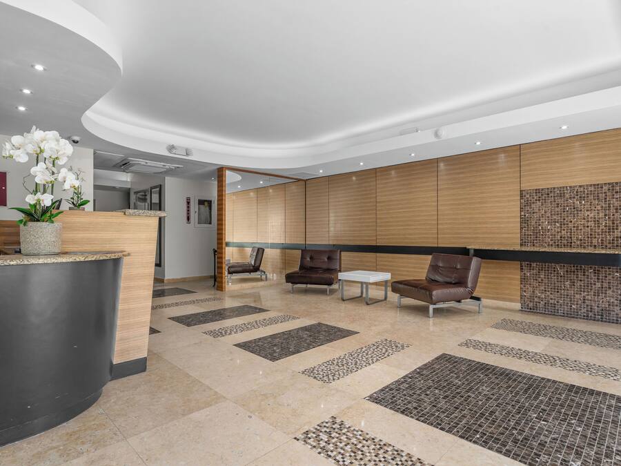 A modern reception area with a curved reception desk, seating area, and decorative tiles.