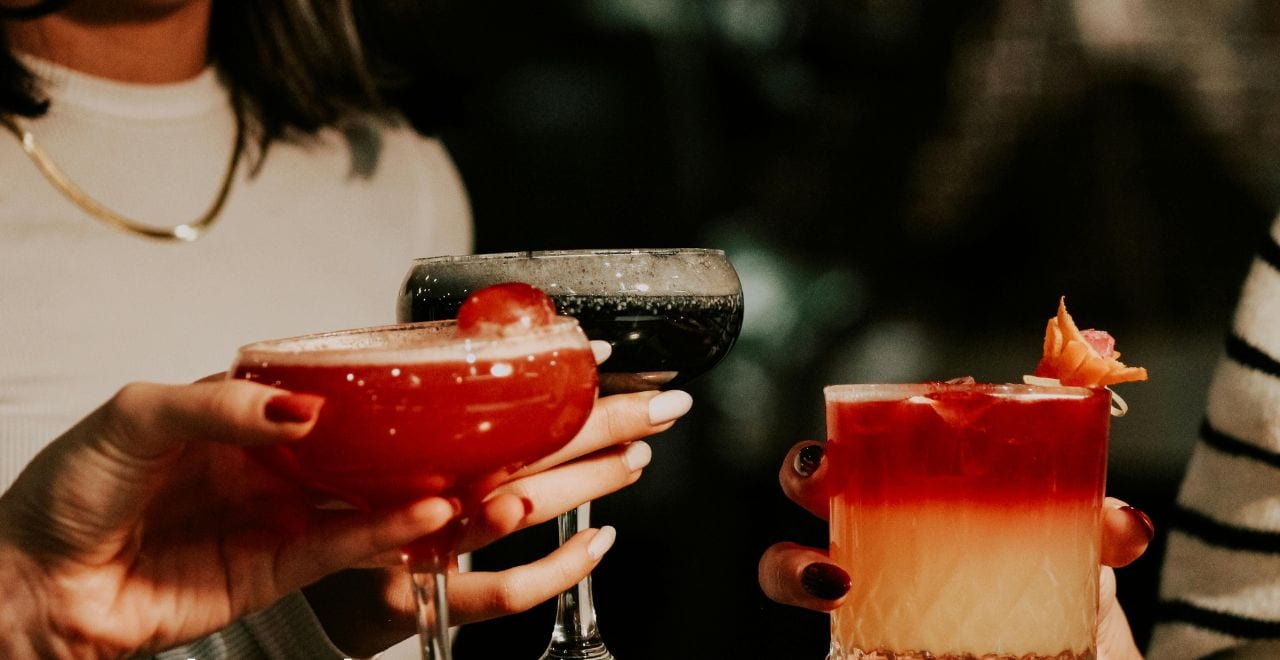 Dos personas sosteniendo bebidas con una descripción de La Placita de Santurce.