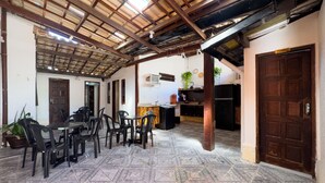 A spacious room with a tiled floor, a dining area with chairs and a table, a kitchen area with a refrigerator, and a door labeled "TORINO".