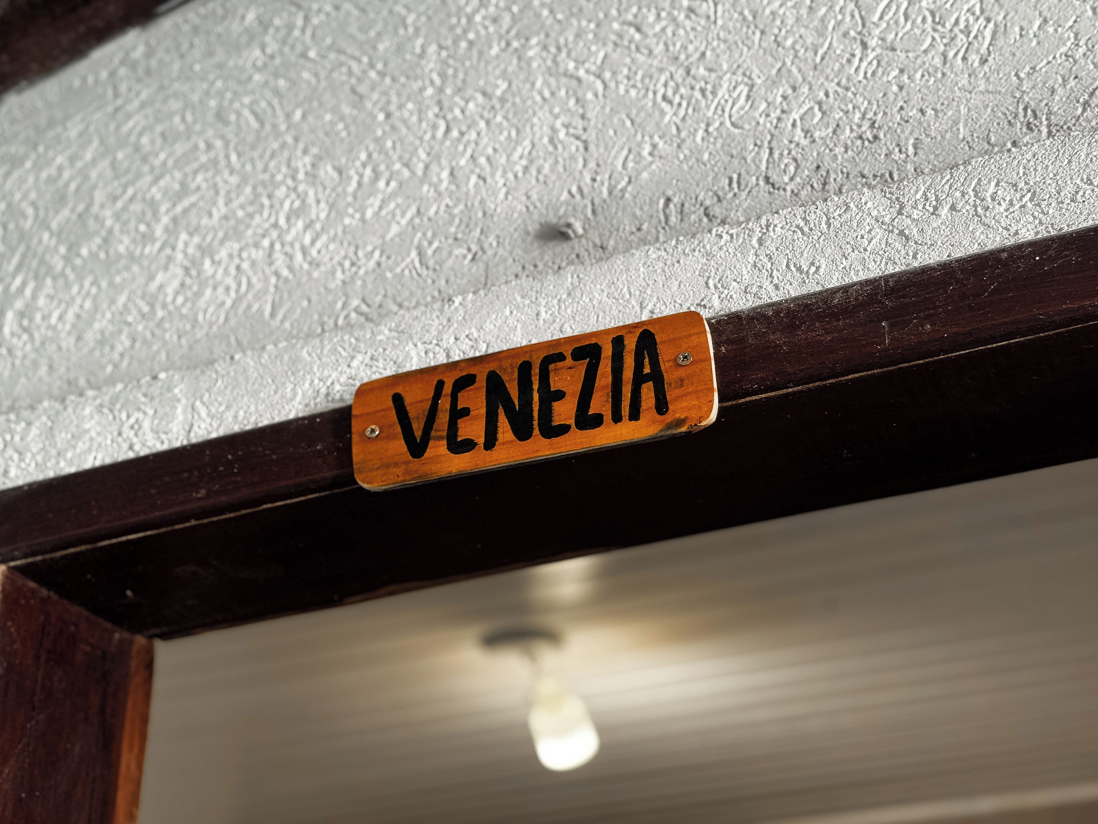 Un segnale di legno con la scritta 'VENEZIA'.