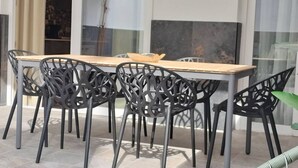 A dining area with a long table and six chairs with intricate metal designs. - Travel Habitat Ruzafa Green House Patio (València)