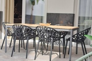 A dining area with a long table and six chairs with intricate metal designs.