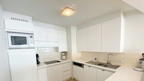A modern kitchen with white cabinetry, a microwave, a blender, a dishwasher, and a sink. - Apartment in Nieuwpoort-bad Near Beach (Nieuwpoort)