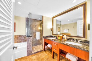 Une salle de bain dotée d’un grand miroir, de deux lavabos, d’une douche et d’un meuble-lavabo avec un porte-serviettes.