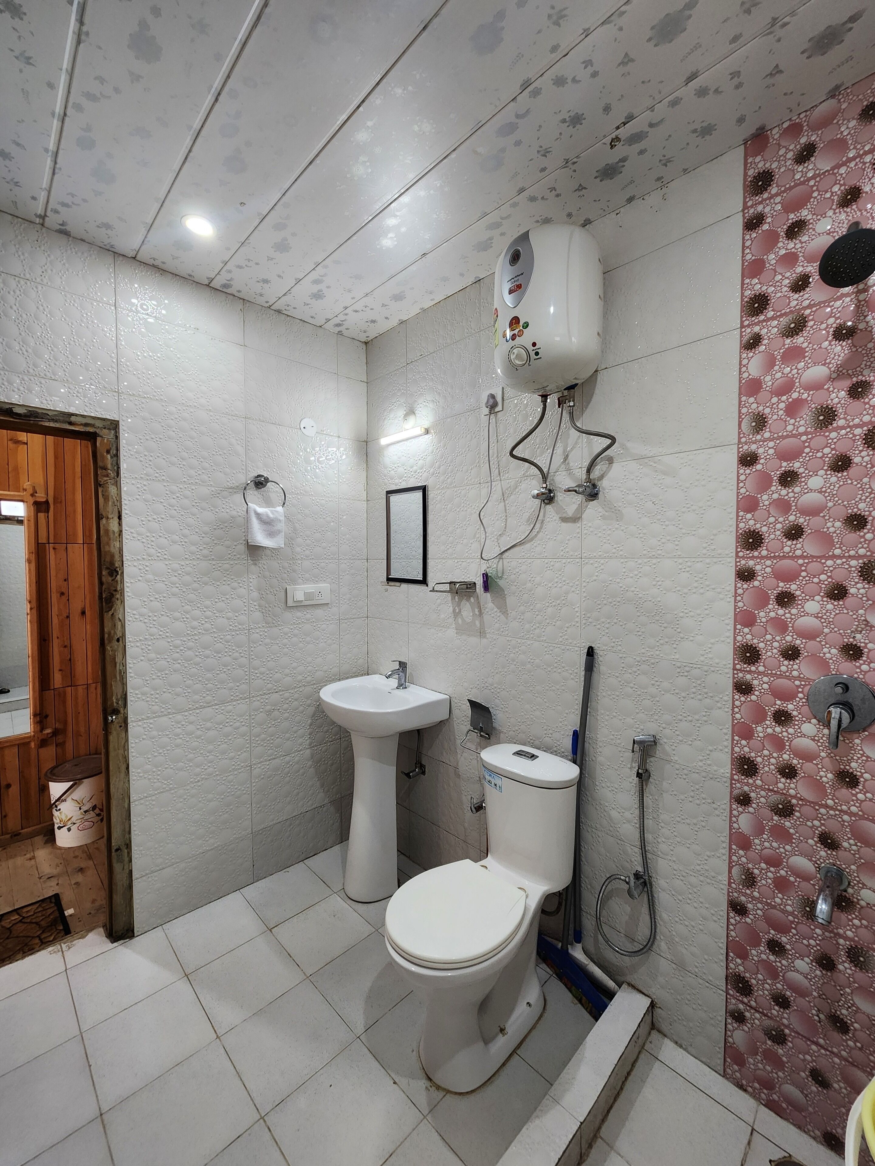 Une salle de bain avec des toilettes, un lavabo et une douche.