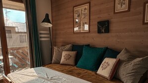 Ein hölzernes Bett mit weißer Decke, Kissen und einem Holz-Kopfteil.